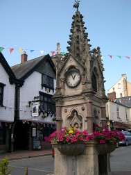 The town clock surrounded by baskets of flowers in Great Torrington.